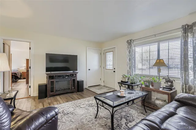 a living room with furniture a flat screen tv and a large window