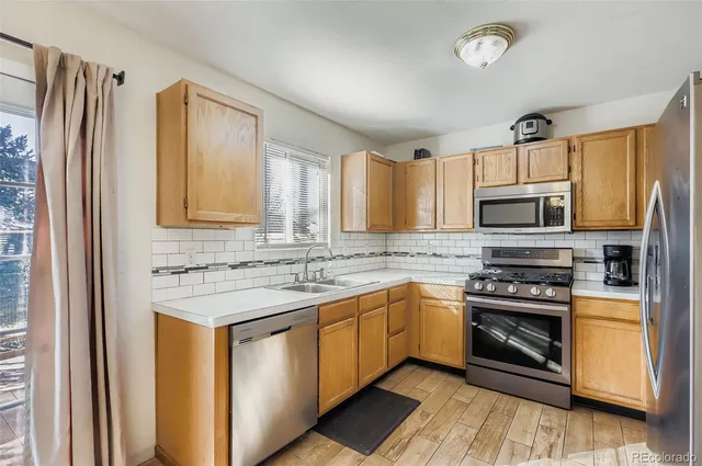a kitchen with stainless steel appliances a stove sink and microwave