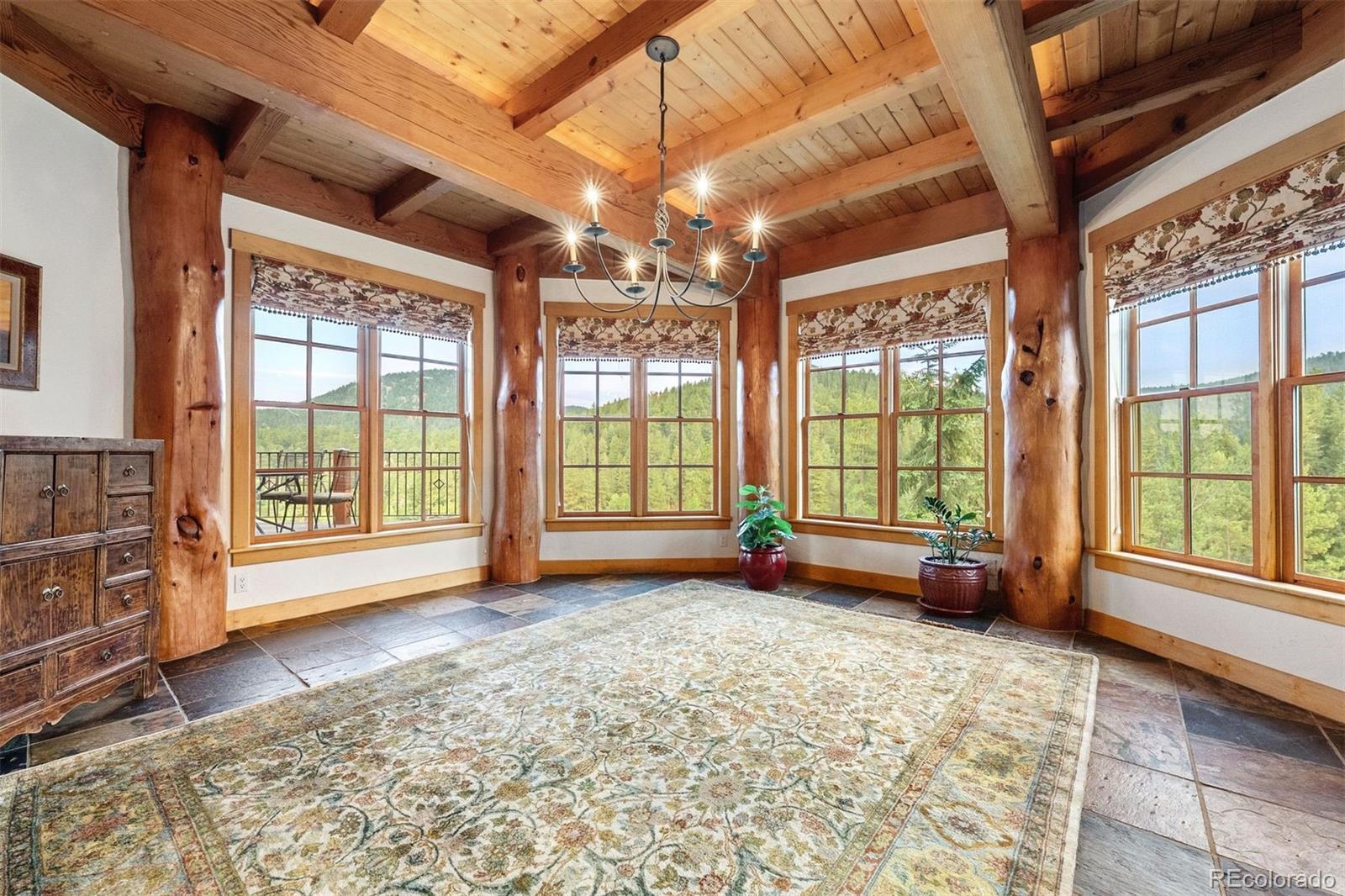 80 Elk Crossing Lane Evergreen, CO 80439 - Photo 12 of 49 a view of an empty room with a fireplace and windows