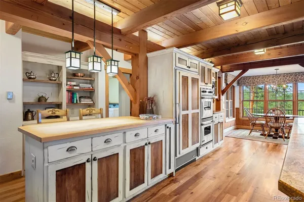 a kitchen with stainless steel appliances sink stove refrigerator and wooden floor