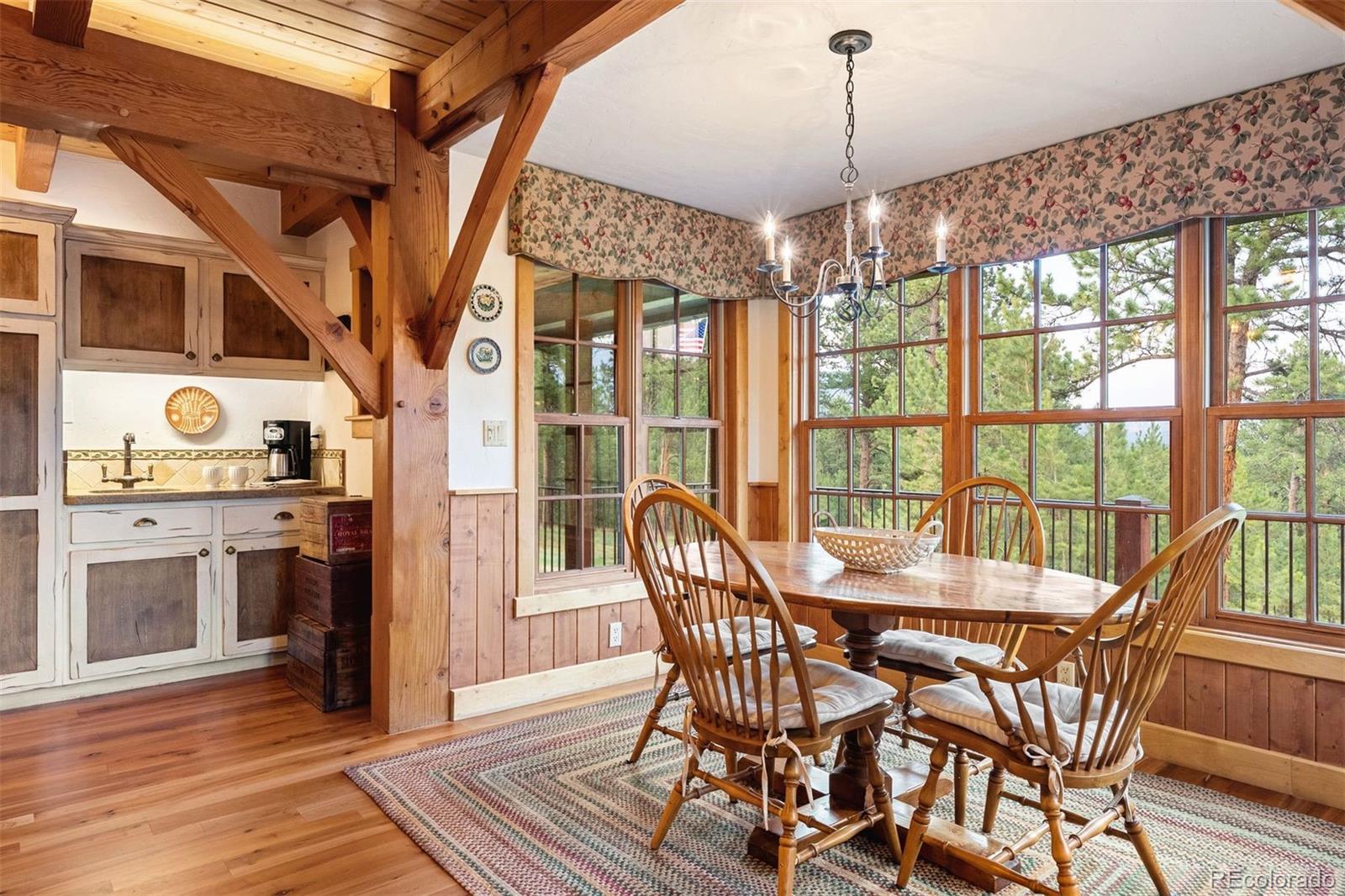 80 Elk Crossing Lane Evergreen, CO 80439 - Photo 18 of 49 a view of a dining room with furniture window and wooden floor