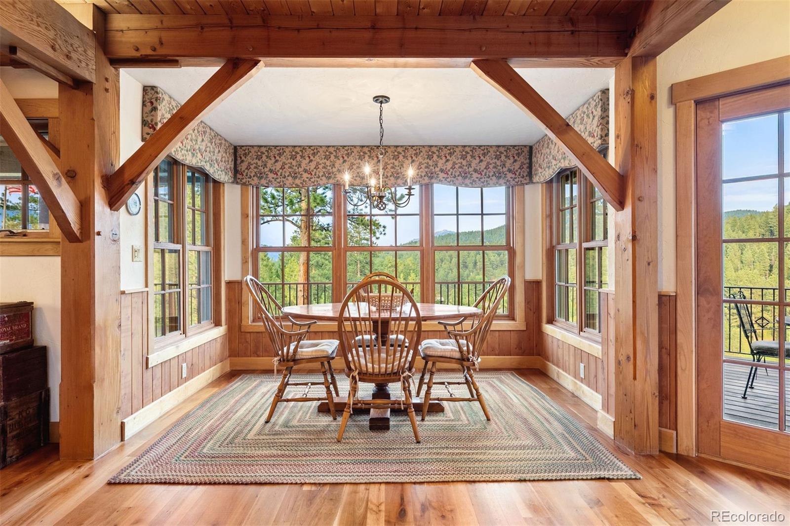80 Elk Crossing Lane Evergreen, CO 80439 - Photo 19 of 49 a dining room with furniture a chandelier and wooden floor