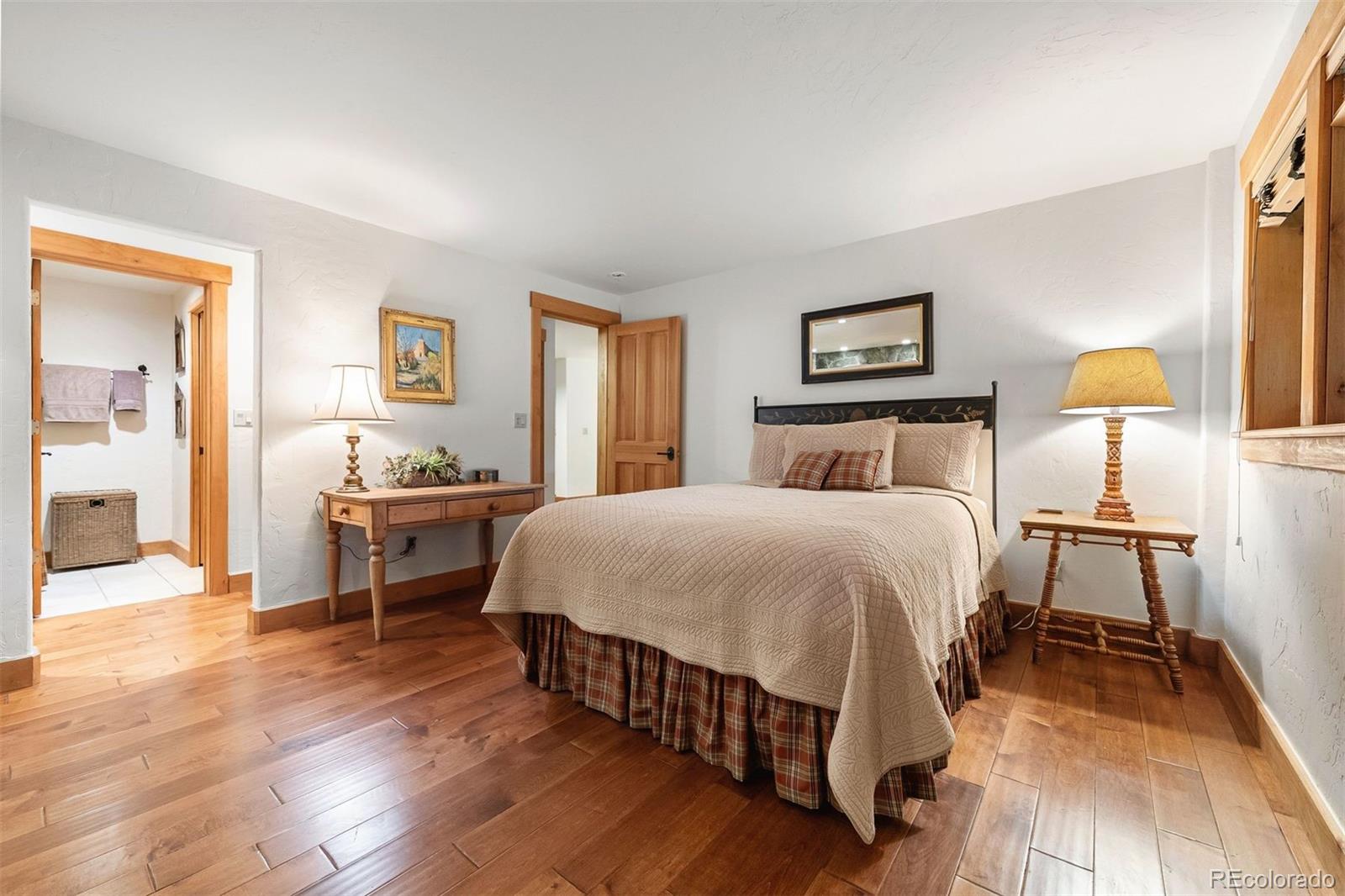 80 Elk Crossing Lane Evergreen, CO 80439 - Photo 43 of 49 a spacious bedroom with a bed and a table in it