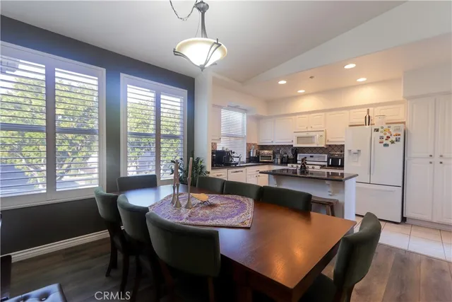 a kitchen with stainless steel appliances granite countertop a sink dining table and chairs