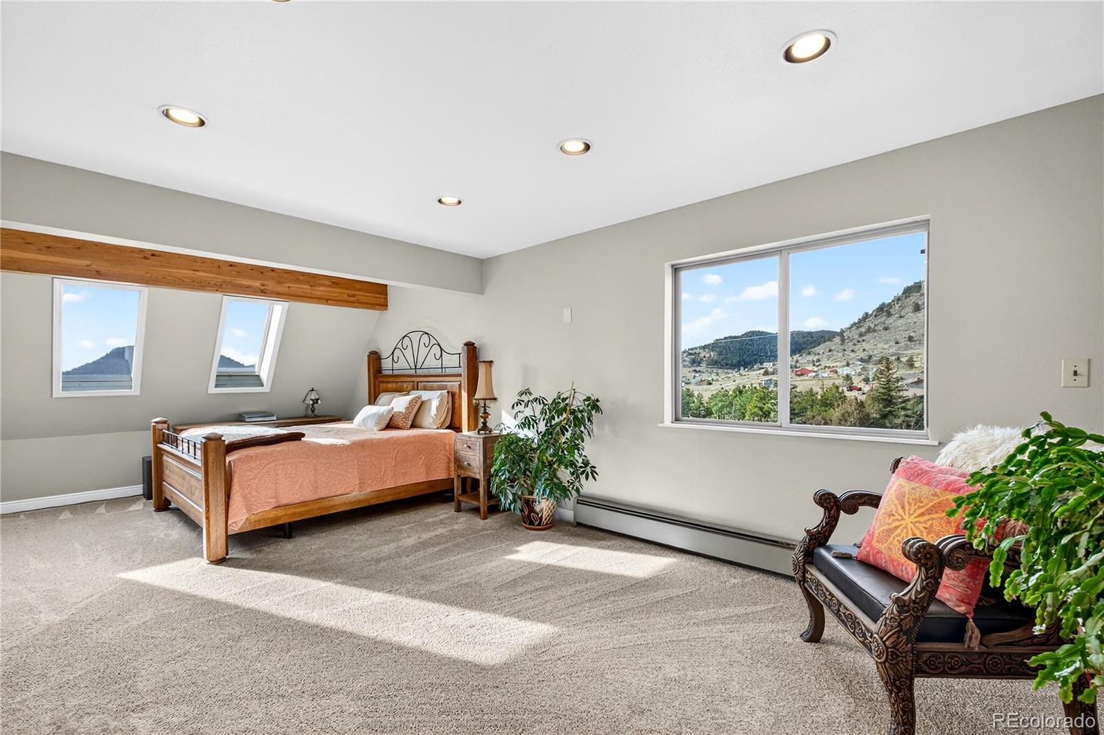 31249 Robinson Hill Road Golden, CO 80403 - Photo 19 of 48 a spacious bedroom with a bed and a window