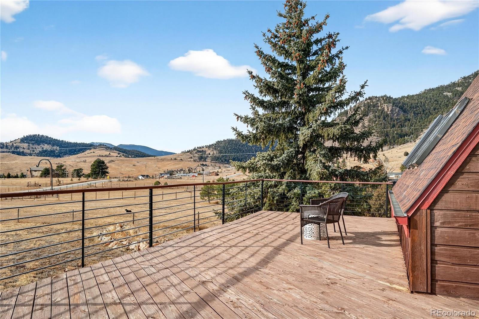 31249 Robinson Hill Road Golden, CO 80403 - Photo 30 of 48 a view of a balcony with chairs and wooden fence