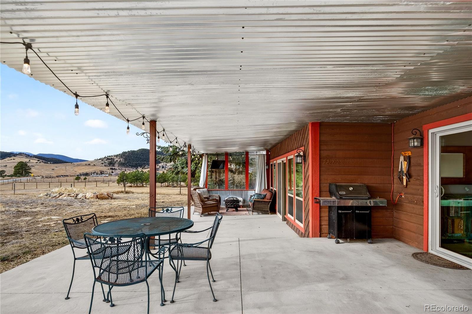 31249 Robinson Hill Road Golden, CO 80403 - Photo 31 of 48 a view of a patio with a table and chairs and wooden floor