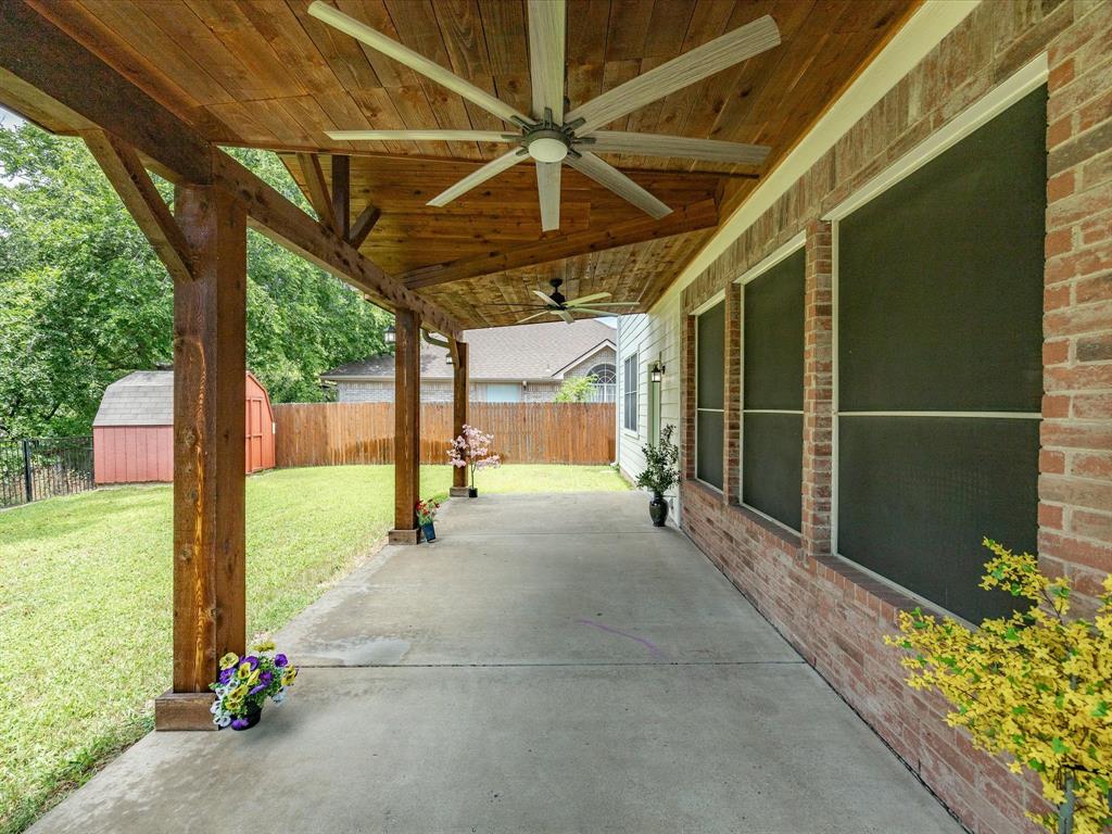 4008 Falcon Ridge Drive Haltom City, TX 76137 - Photo 34 of 40 Covered concrete patio featuring wood-finish ceiling, exposed beams, and multiple ceiling fans