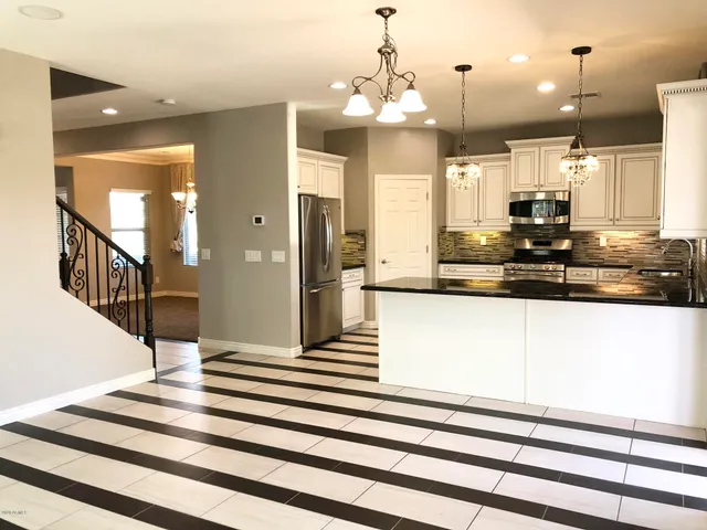 a view of a kitchen with kitchen island a refrigerator and a stove