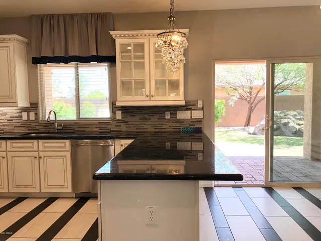 a kitchen with granite countertop wooden cabinets a sink a stove and a window