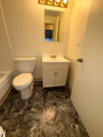 a bathroom with a sink toilet and mirror