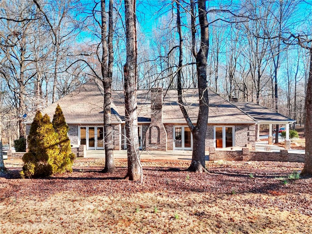 66 Highland Drive Jefferson, GA 30549 - Photo 56 of 63 a view of a white house with a large tree and a yard
