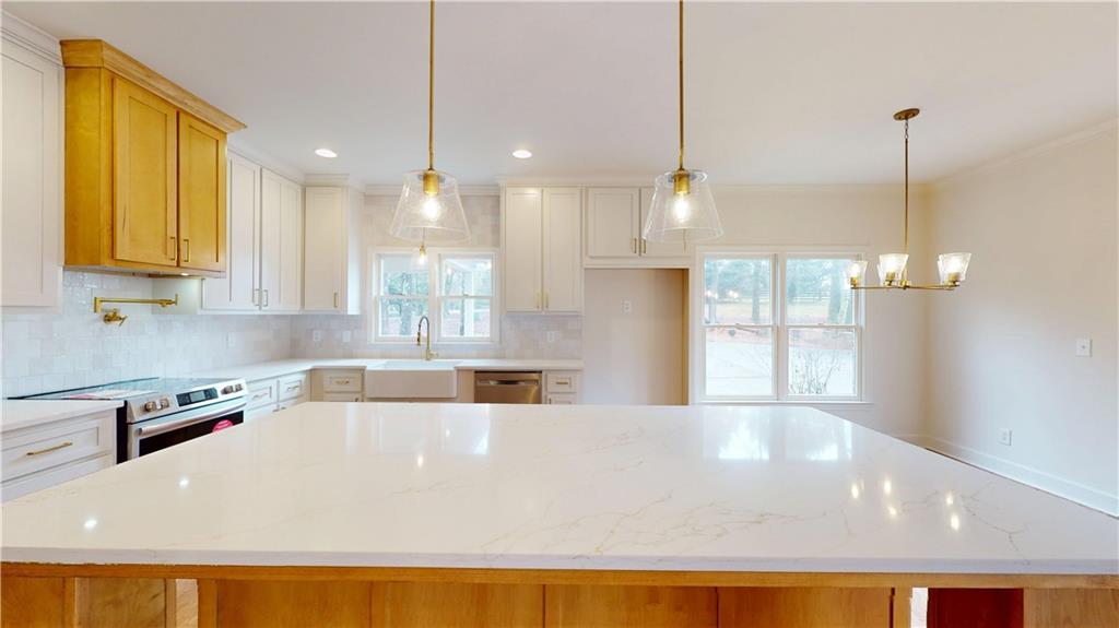 66 Highland Drive Jefferson, GA 30549 - Photo 9 of 63 a large white kitchen with a large window a oven a counter space and a sink