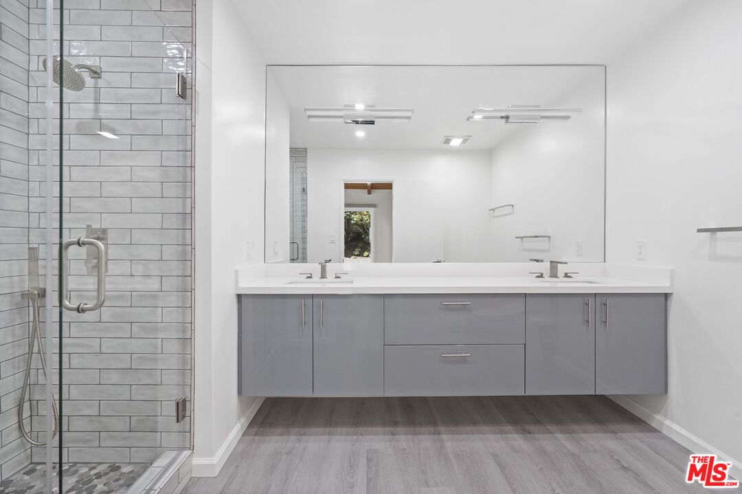 31259 Bailard Road Malibu, CA 90265 - Photo 11 of 43 a bathroom with a double vanity sink a mirror and shower
