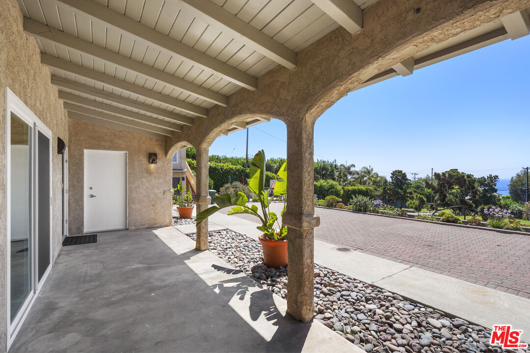 31259 Bailard Road Malibu, CA 90265 - Photo 34 of 43 a porch with a table and chairs and potted plants