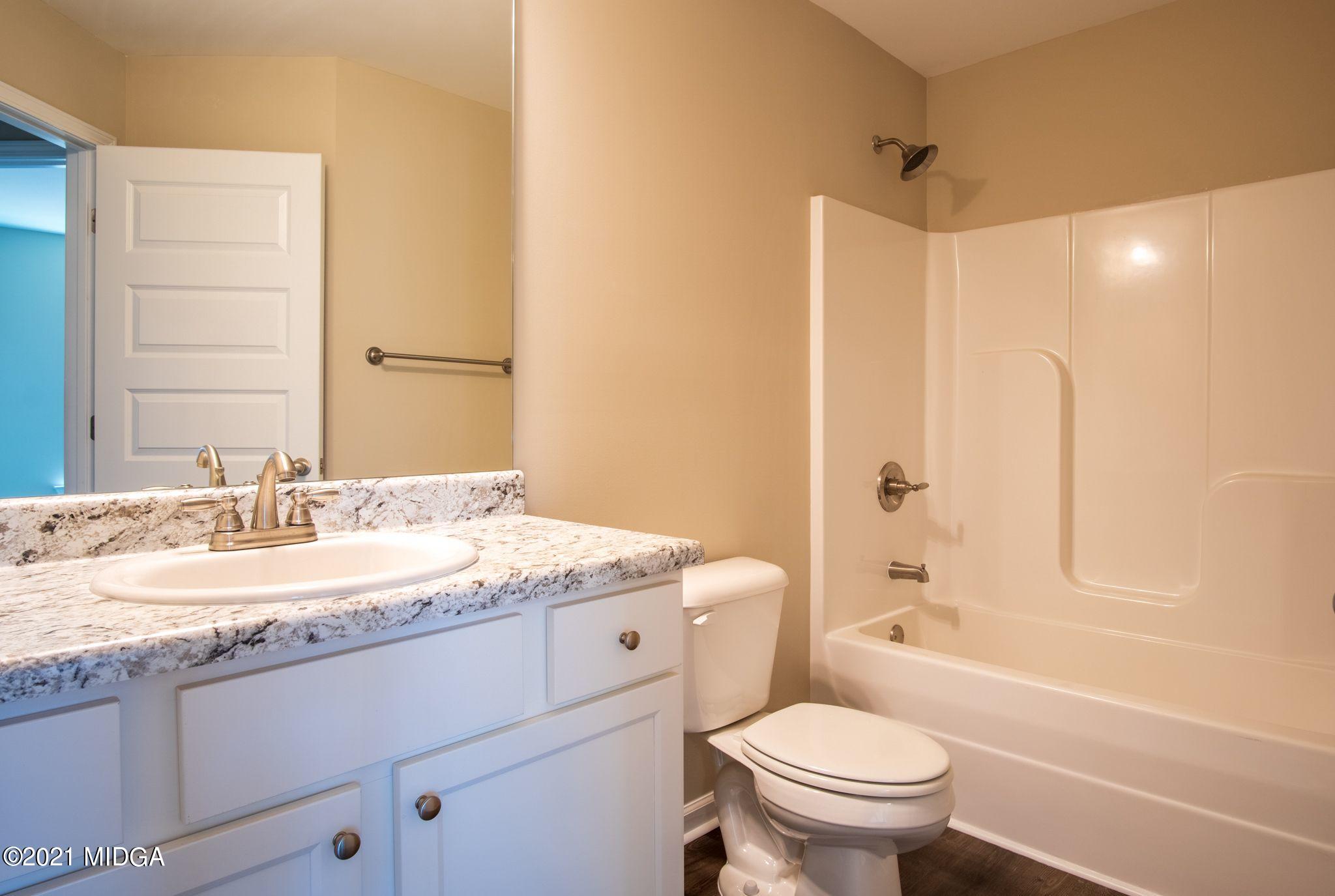 333 Pond View Road Macon, GA 31206 - Photo 11 of 22 a bathroom with a granite countertop sink toilet mirror and a bathtub