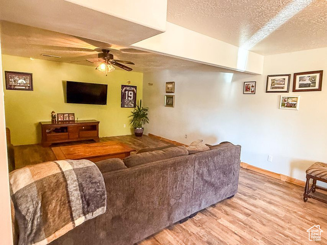 425 East Mule Deer Road Central, UT 84722 - Photo 35 of 72 Living room with a textured ceiling, light wood-style flooring, ceiling fan, and baseboards