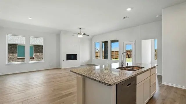 a kitchen with granite countertop kitchen island a sink appliances and a counter space