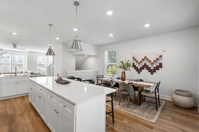 a kitchen with a sink a stove a dining table and chairs