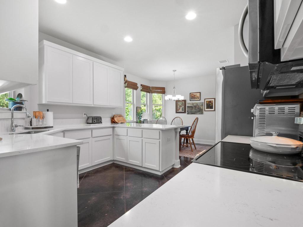 10103 Twin Lake Loop Dripping Springs, TX 78620 - Photo 13 of 32 Kitchen featuring a sink, a peninsula, white cabinets, recessed lighting, and a chandelier