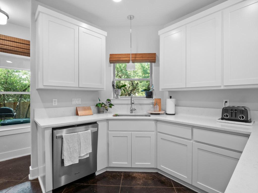 10103 Twin Lake Loop Dripping Springs, TX 78620 - Photo 15 of 32 Kitchen with a sink, dishwasher, light countertops, and white cabinetry