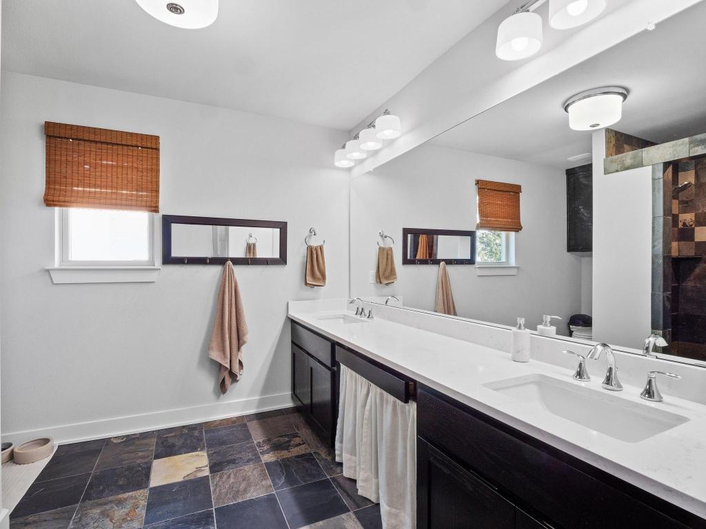 10103 Twin Lake Loop Dripping Springs, TX 78620 - Photo 24 of 32 Full bath with baseboards, double vanity, a tile shower, and stone finish flooring