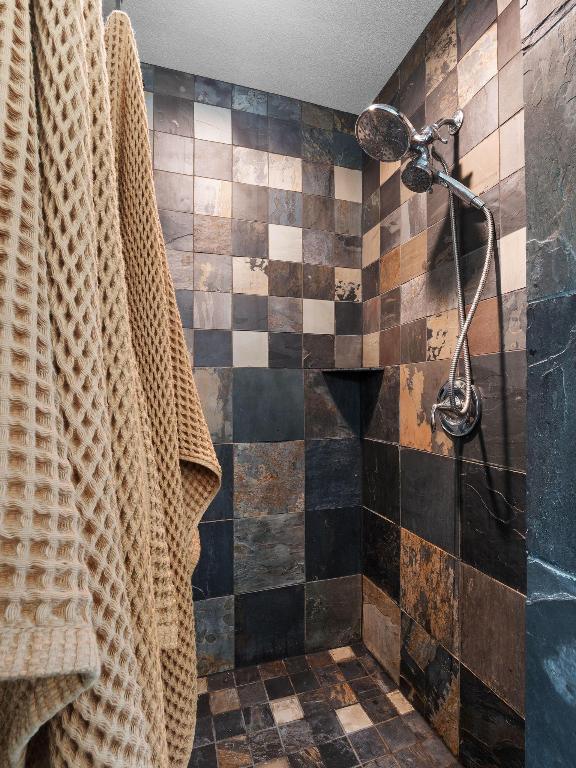 10103 Twin Lake Loop Dripping Springs, TX 78620 - Photo 26 of 32 Full bathroom with stone finish floors and tiled shower