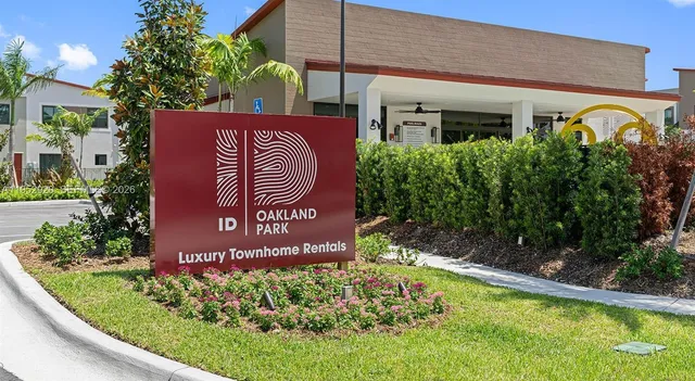 a view of a house with a garden and signage