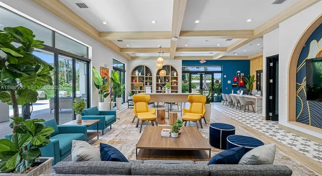 a living room with furniture kitchen view and large windows