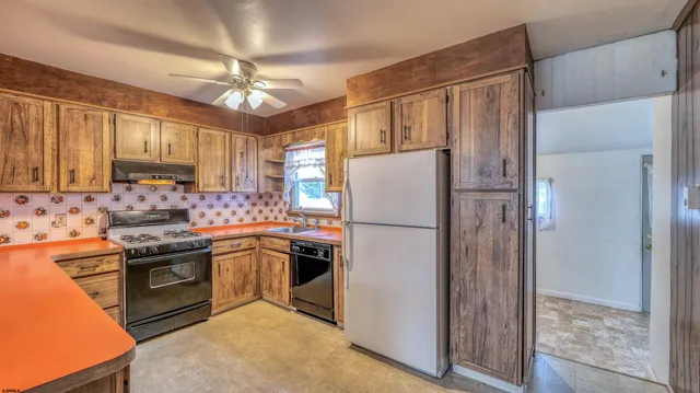 a kitchen with stainless steel appliances granite countertop a refrigerator a stove a sink and a refrigerator