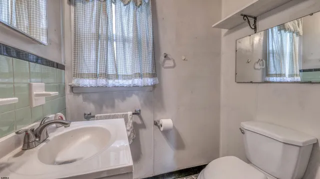 a bathroom with a sink toilet and mirror