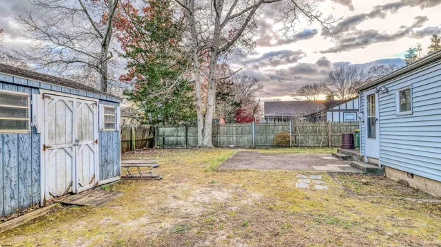 a view of a yard with wooden fence