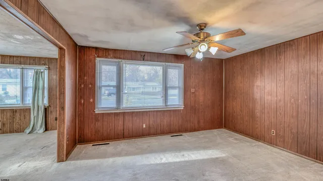 an empty room with a ceiling fan and a window