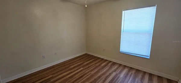 a view of a small space with wooden floor and a window