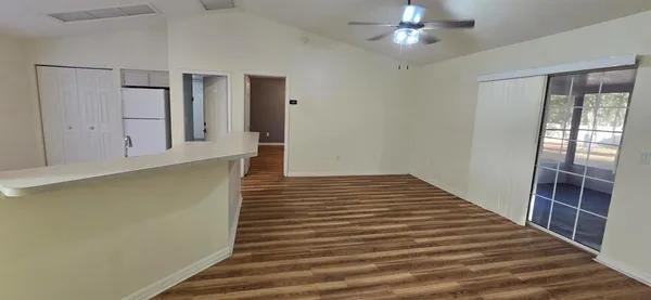 a view of a hallway with wooden floor and chandelier