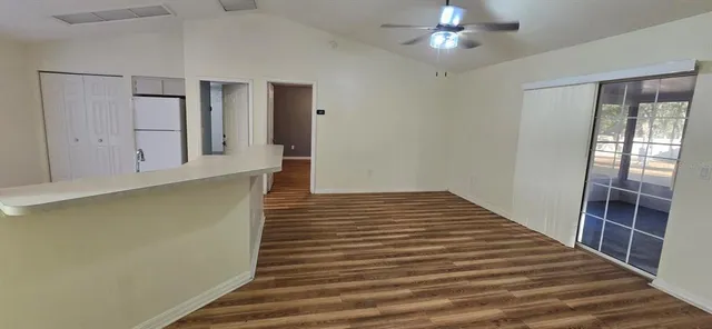 a view of a hallway with wooden floor and chandelier