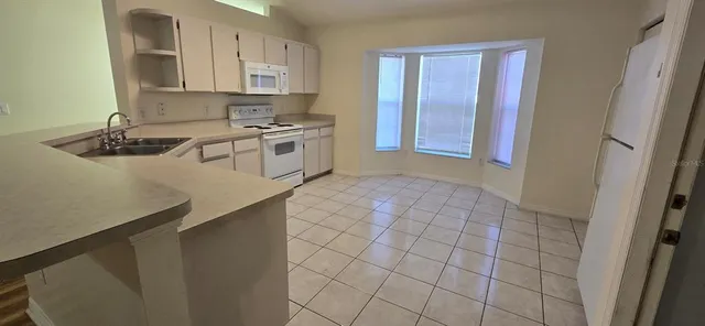 a kitchen with a sink a stove and cabinets