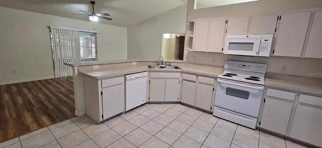 a kitchen with white cabinets and white appliances