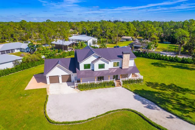 an aerial view of a house with swimming pool garden and lake view