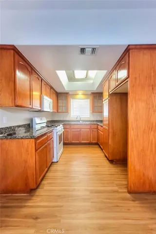 a large kitchen with stainless steel appliances granite countertop a refrigerator and a stove top oven