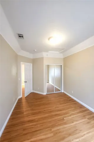 a view of empty room with wooden floor