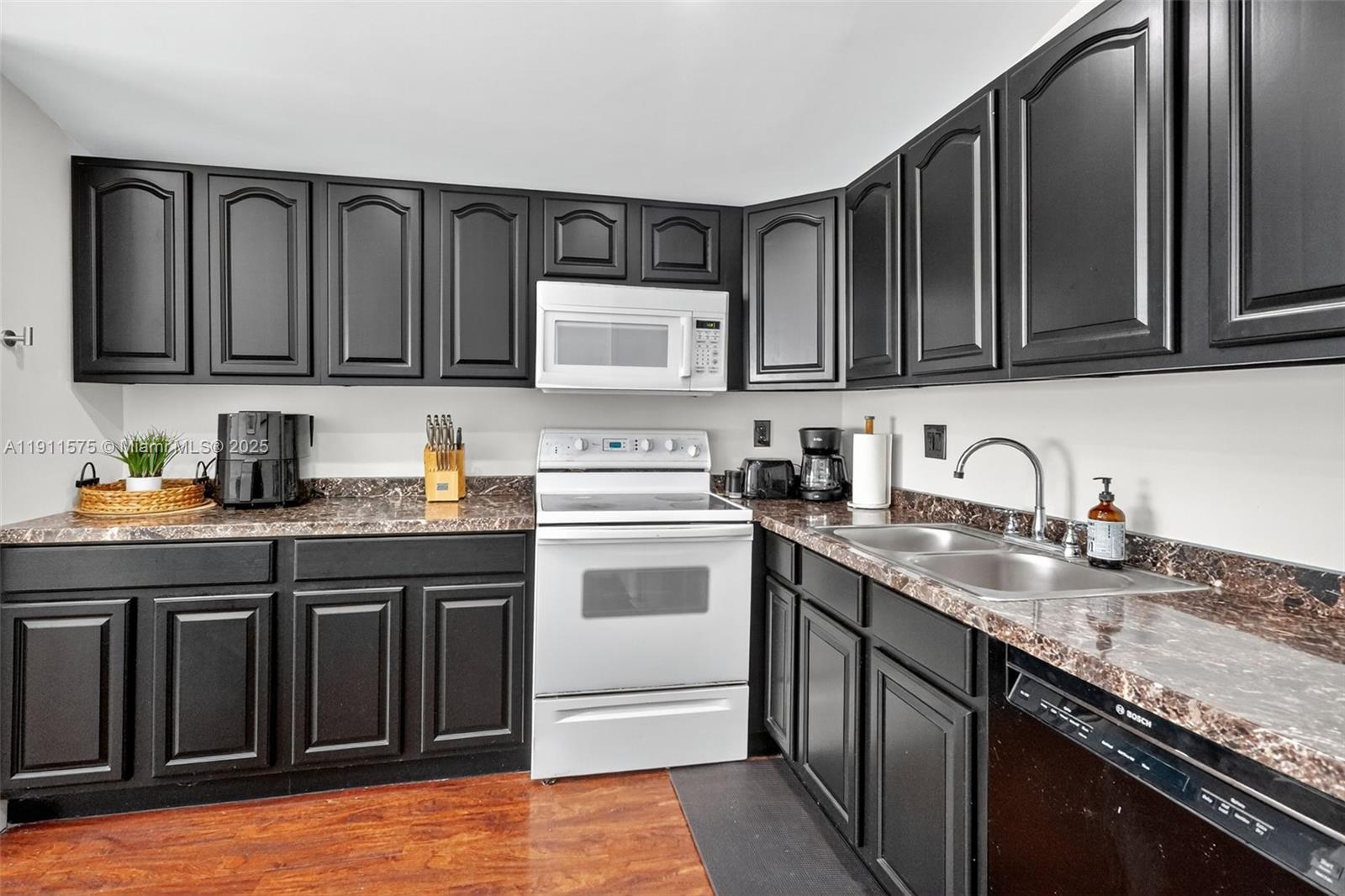 765 Northwest 46th Street Miami, FL 33127 - Photo 11 of 40 a kitchen with granite countertop a sink stove and cabinets
