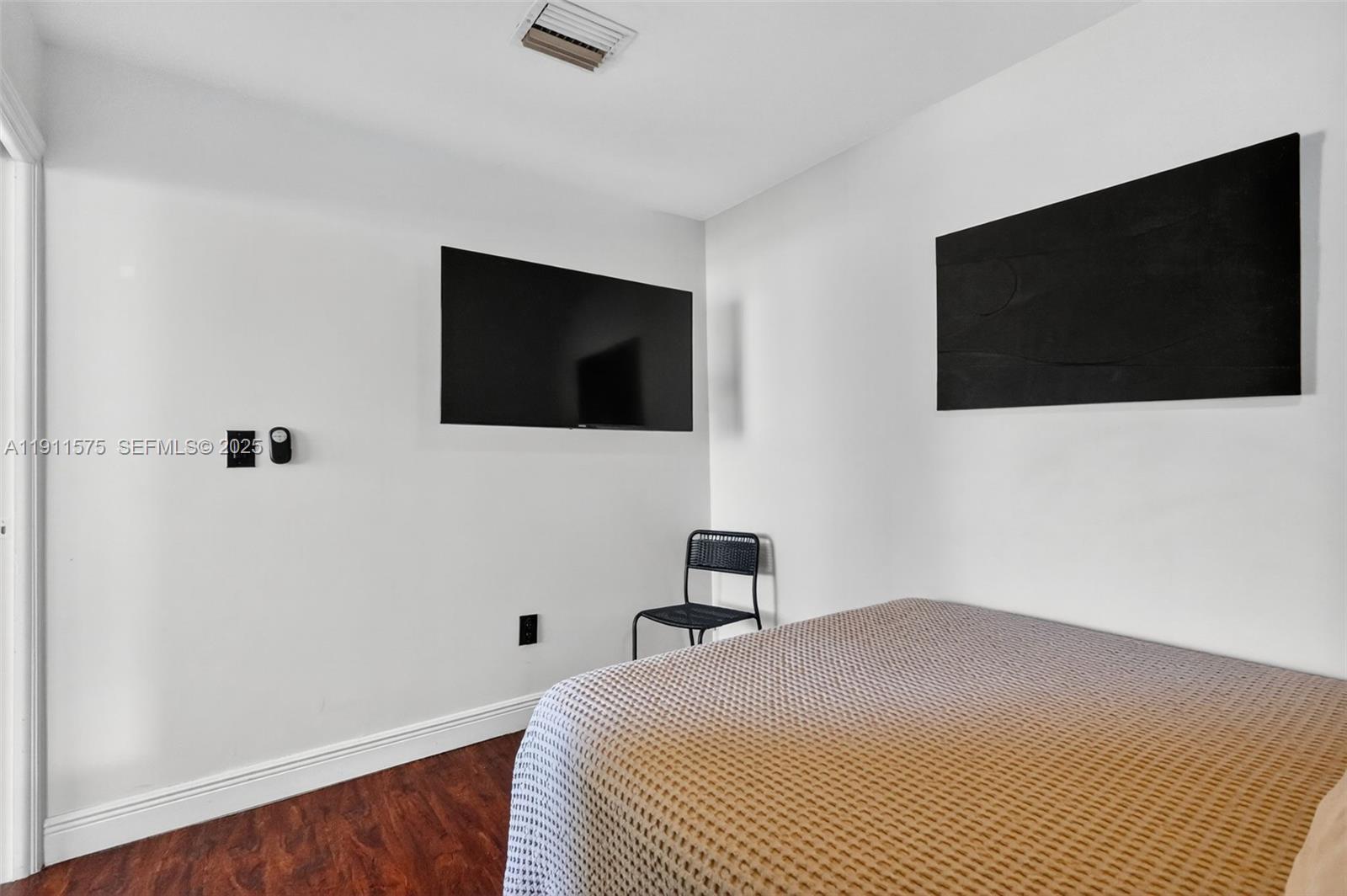 765 Northwest 46th Street Miami, FL 33127 - Photo 13 of 40 a bedroom with a bed and a flat screen tv