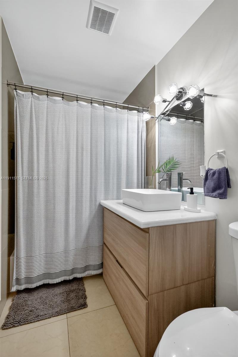 765 Northwest 46th Street Miami, FL 33127 - Photo 15 of 40 a bathroom with a sink a mirror and a toilet