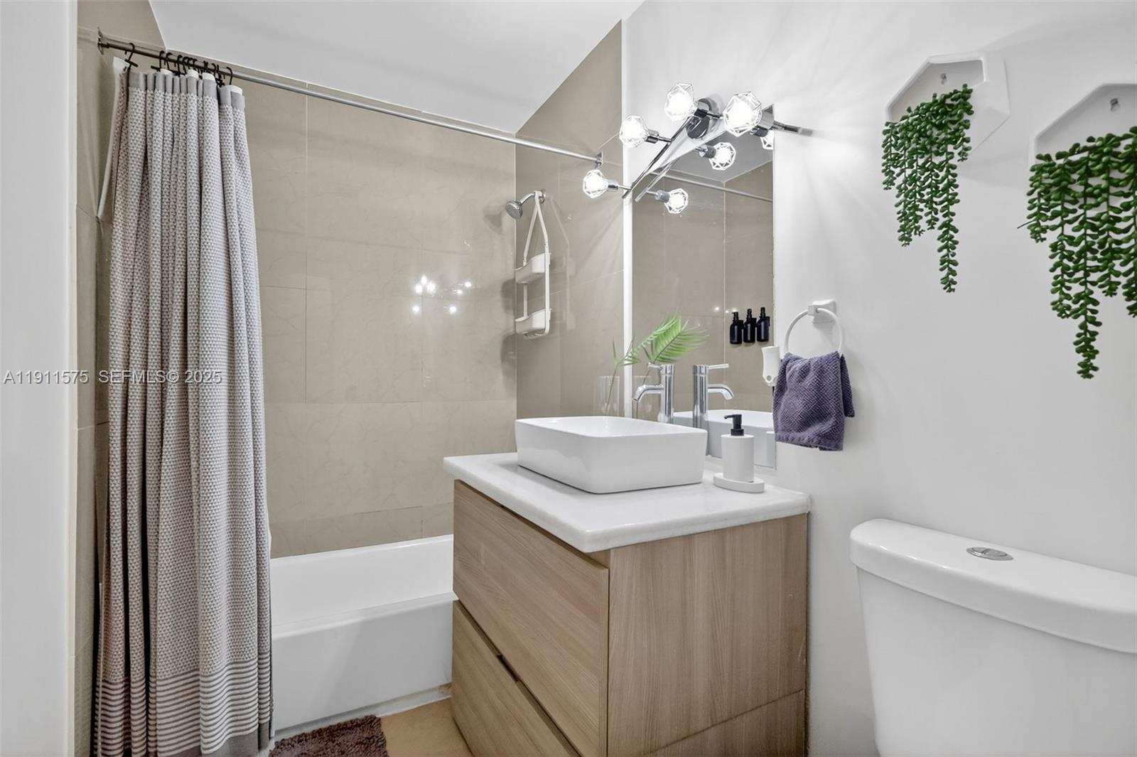 765 Northwest 46th Street Miami, FL 33127 - Photo 17 of 40 a bathroom with a granite countertop sink a toilet a mirror and shower