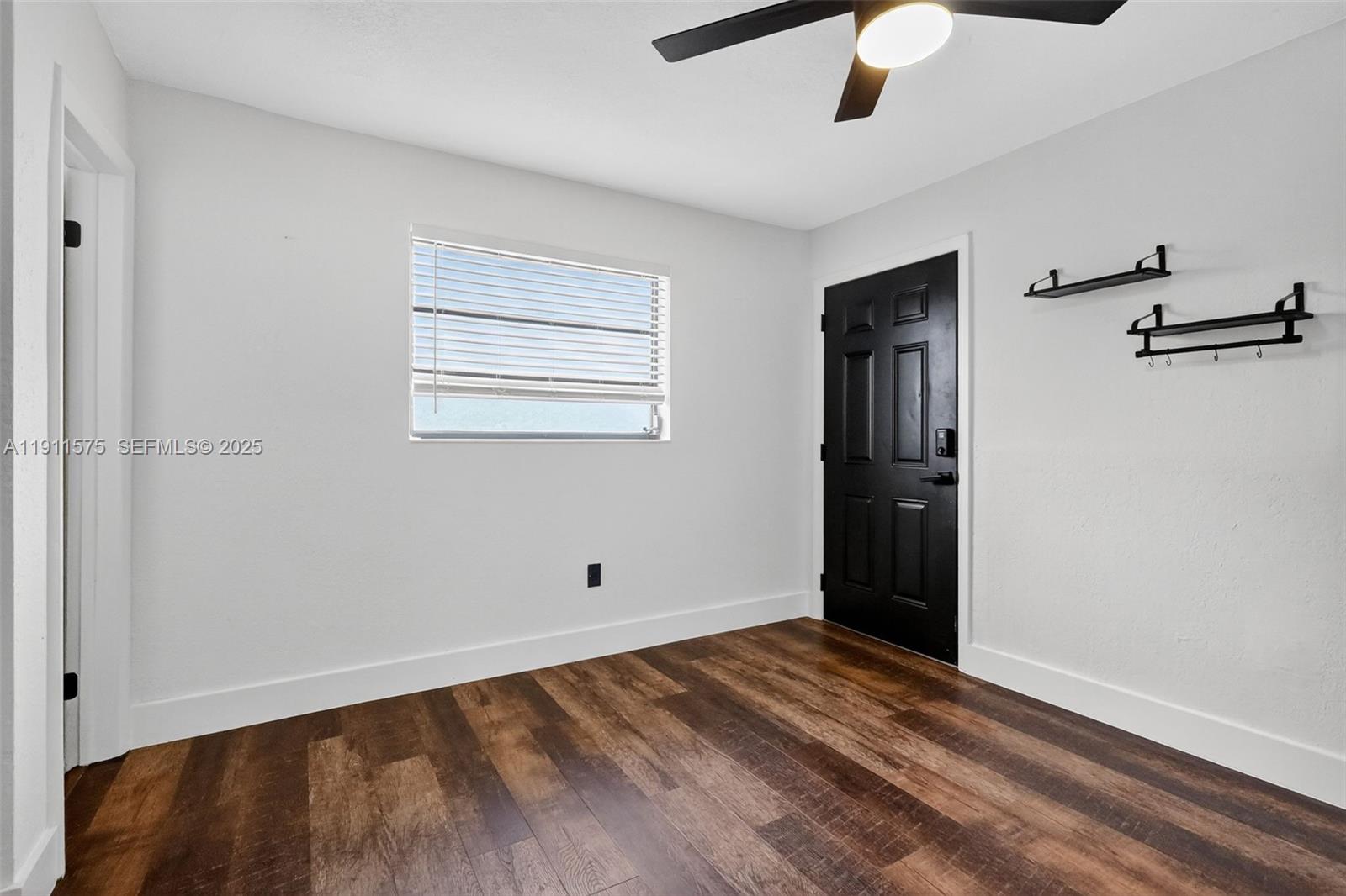 765 Northwest 46th Street Miami, FL 33127 - Photo 23 of 40 a view of an empty room with wooden floor and a window