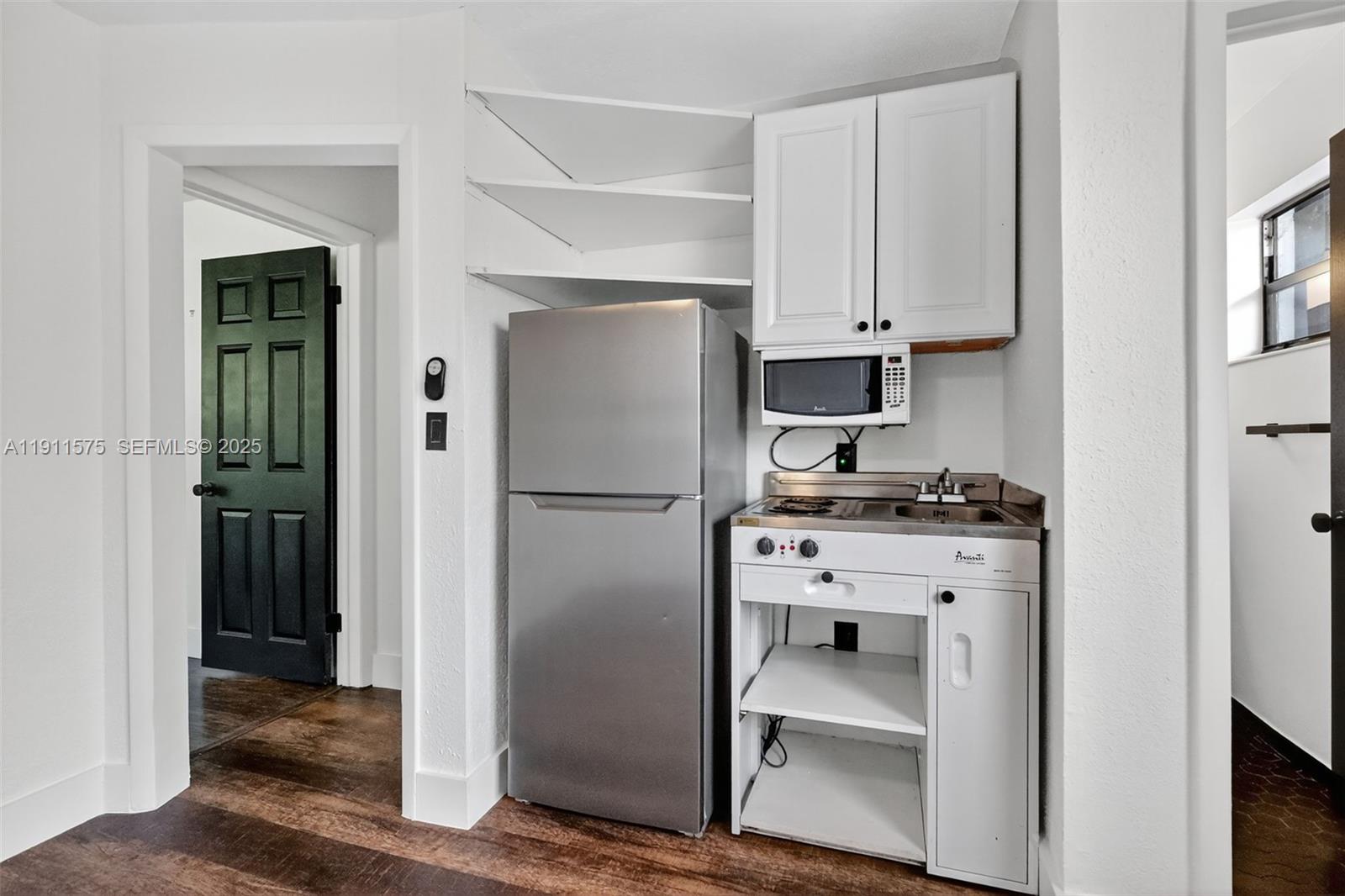 765 Northwest 46th Street Miami, FL 33127 - Photo 24 of 40 a kitchen with white cabinets and stainless steel appliances