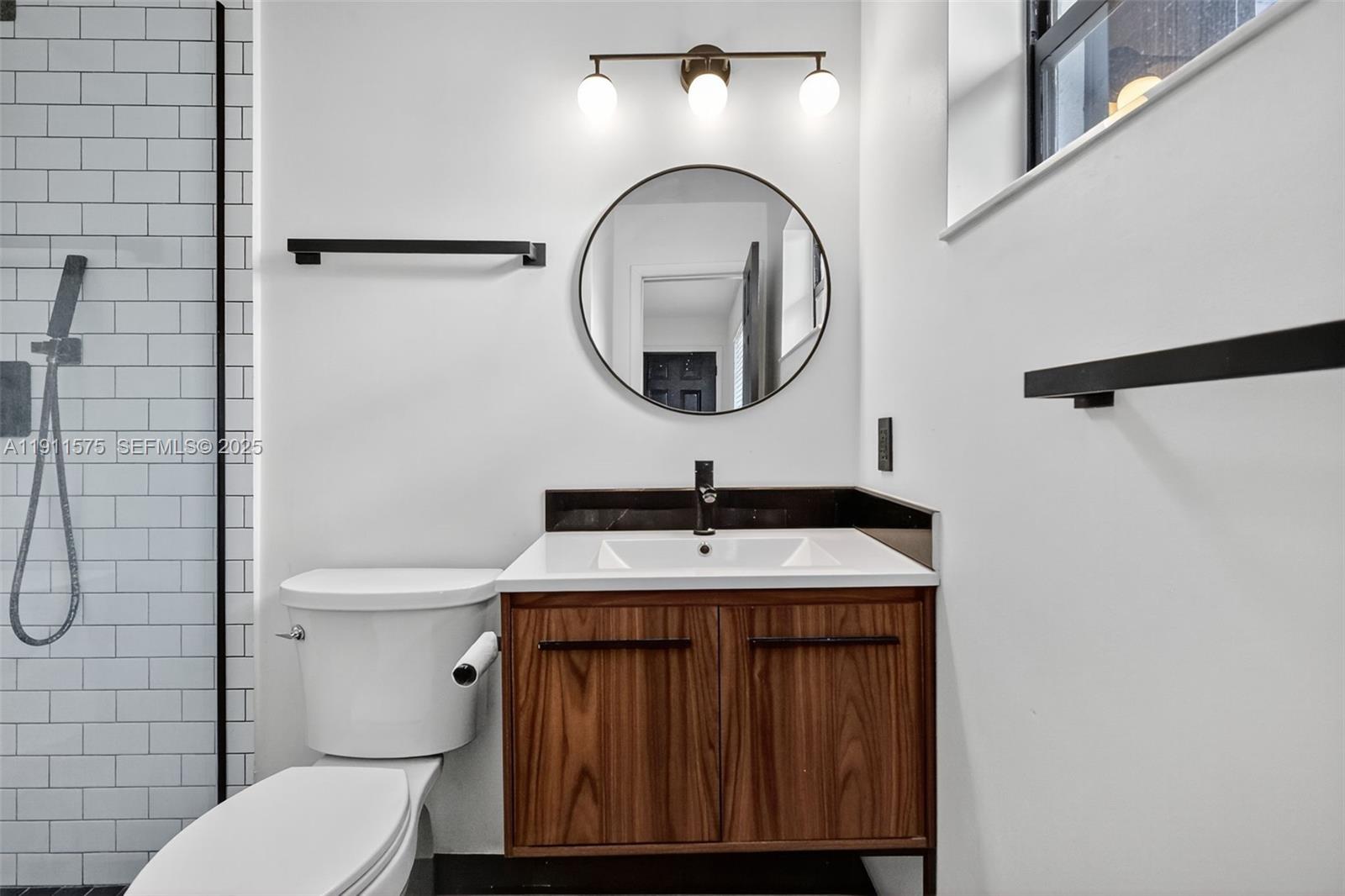 765 Northwest 46th Street Miami, FL 33127 - Photo 26 of 40 a bathroom with a granite countertop toilet sink and mirror