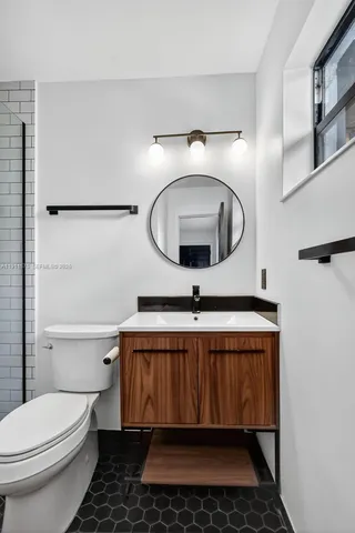 a bathroom with a sink toilet and mirror