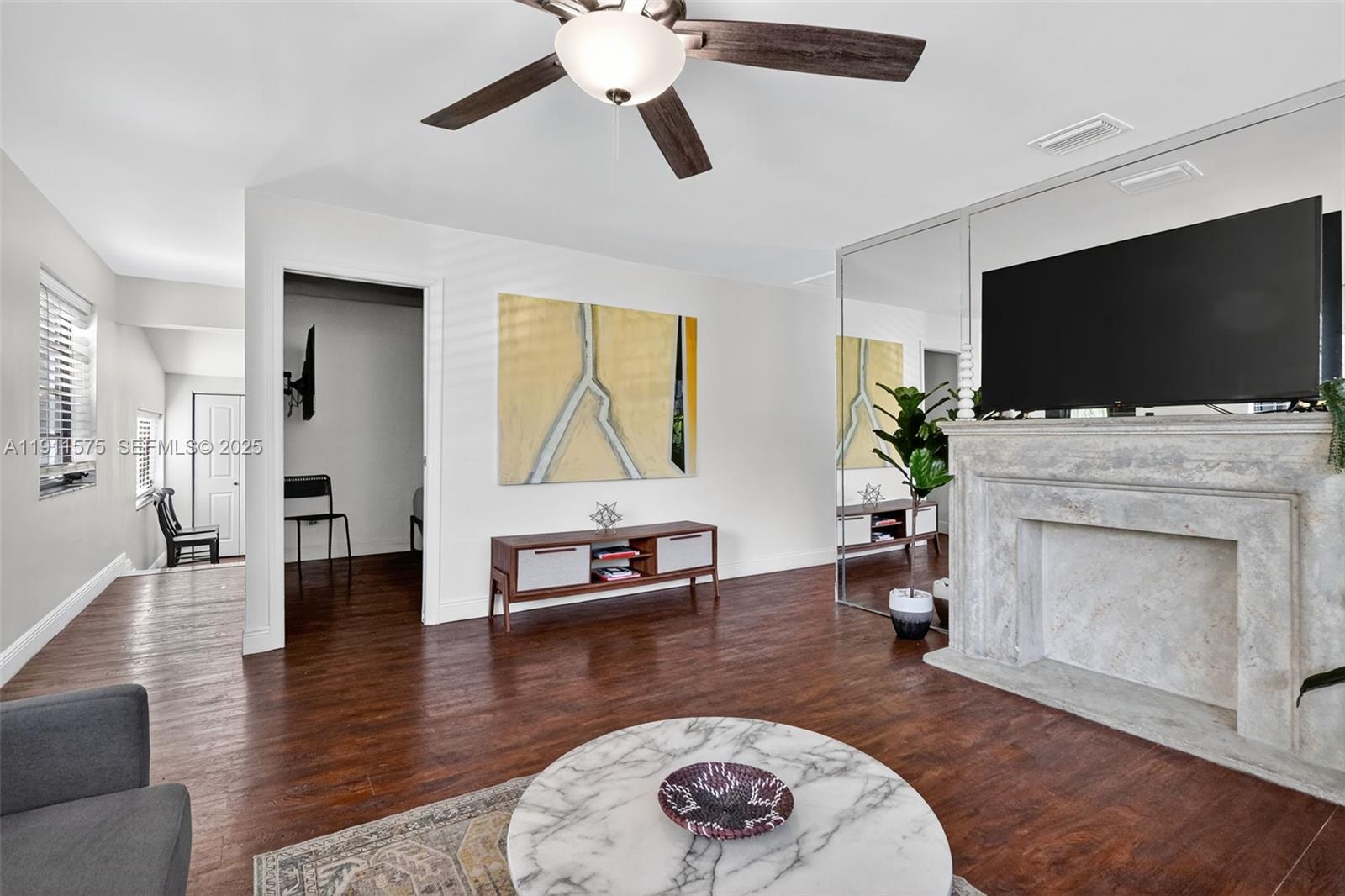 765 Northwest 46th Street Miami, FL 33127 - Photo 6 of 40 a living room with furniture a fireplace and a flat screen tv
